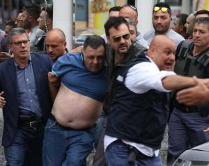 L'arresto dell'uomo che ha ucciso quattro persone sparando dal balcone (foto Ansa)